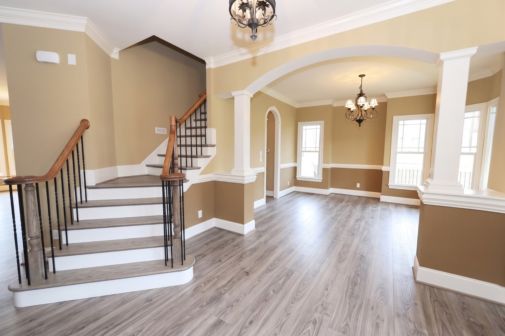 Completed gray vinyl plank flooring throughout an open living and dining room
