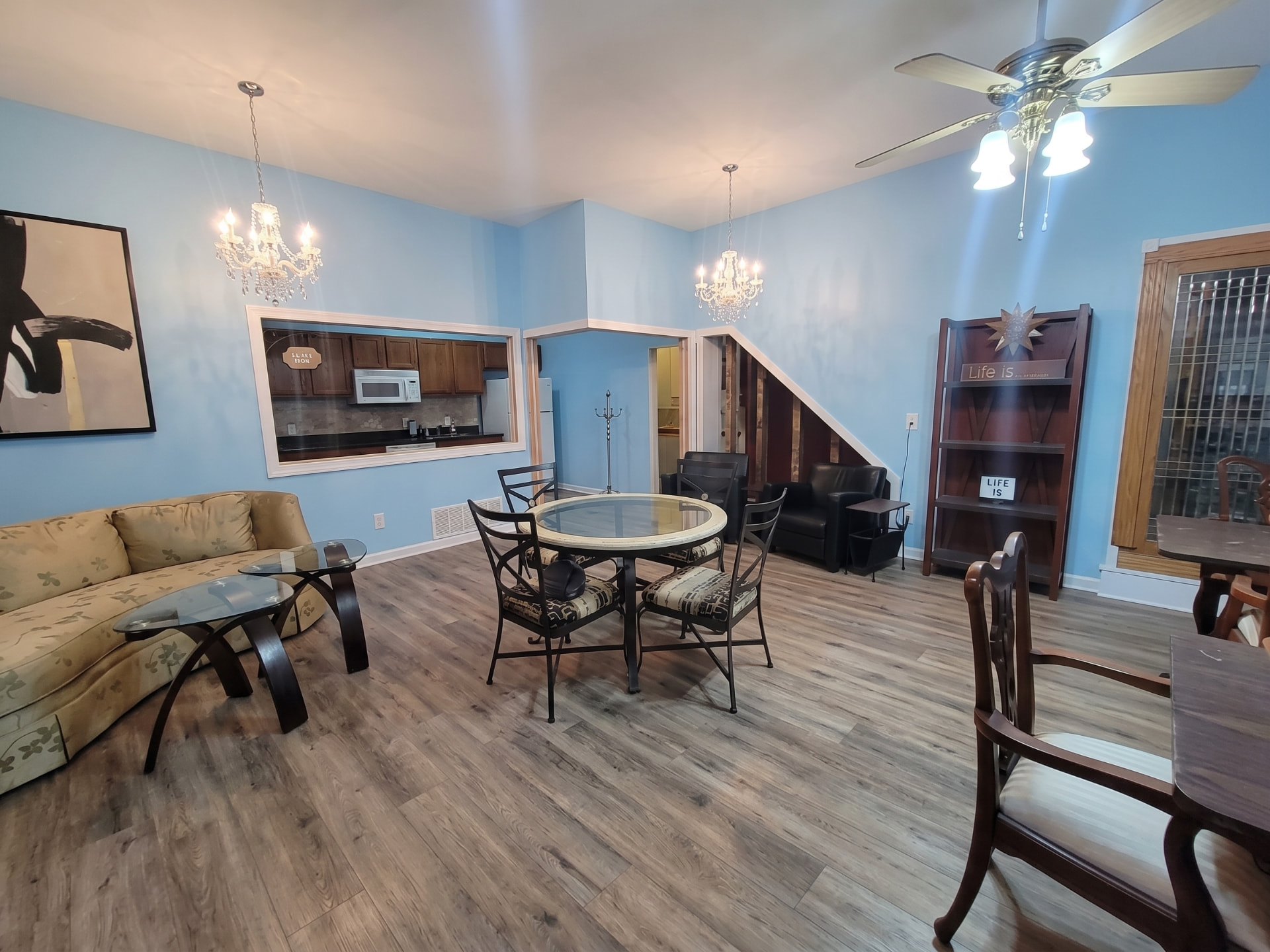Vinyl plank flooring in a bright multi-use rental lounge and kitchenette space