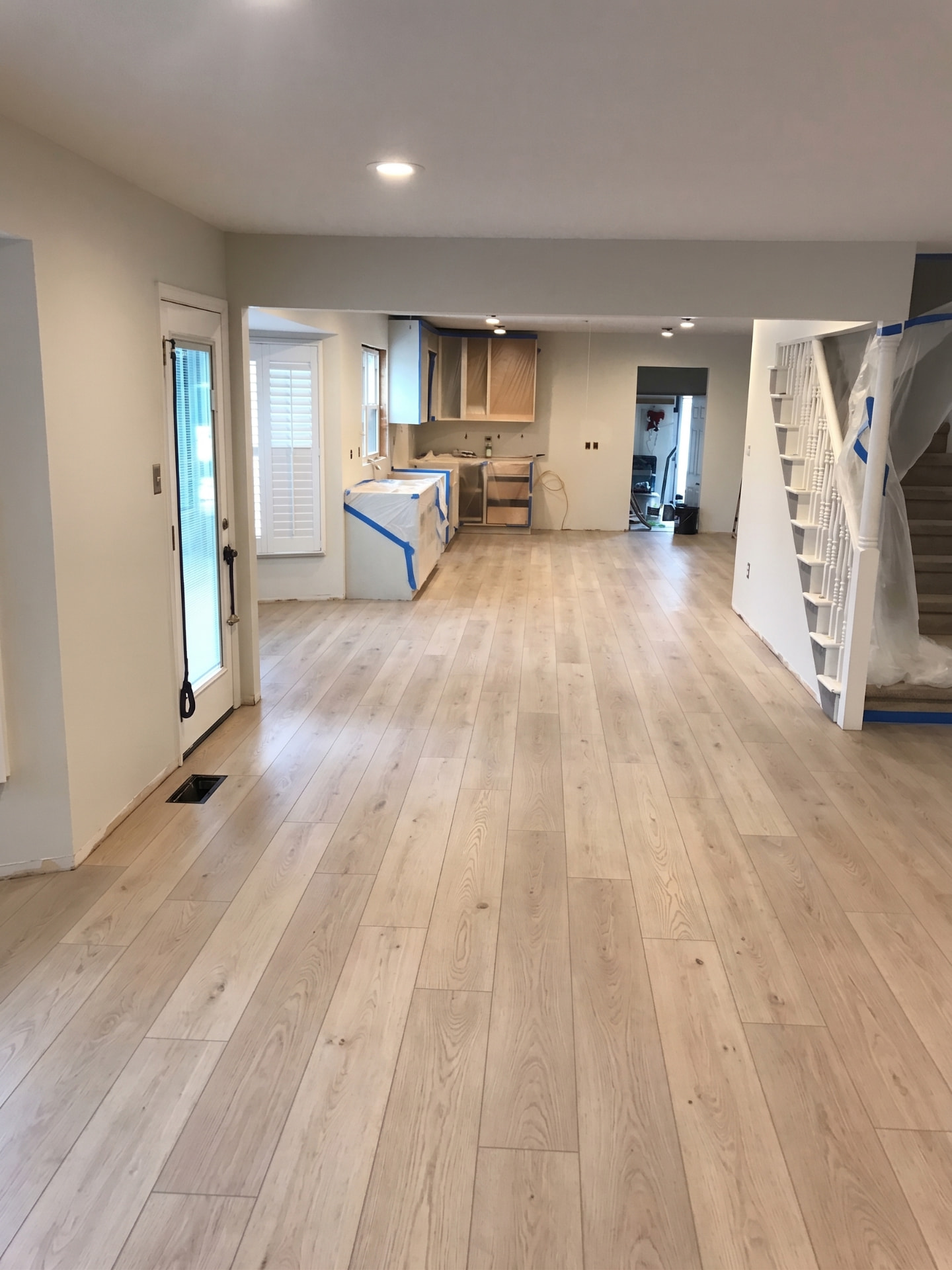 Completed light oak vinyl plank flooring in an open-plan home renovation