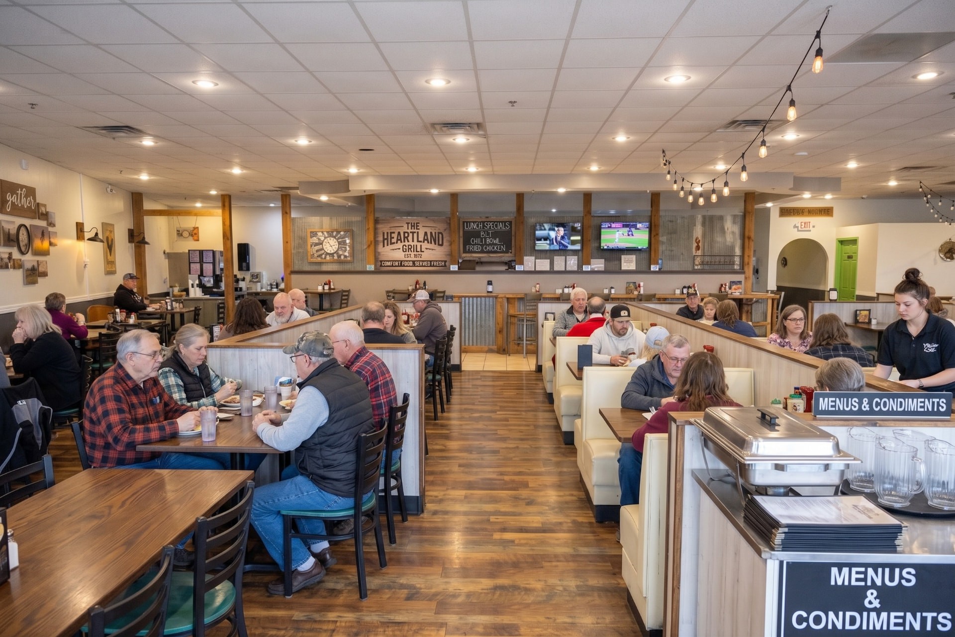 Commercial wood-look vinyl plank flooring installed in a busy restaurant dining room with booths and tables
